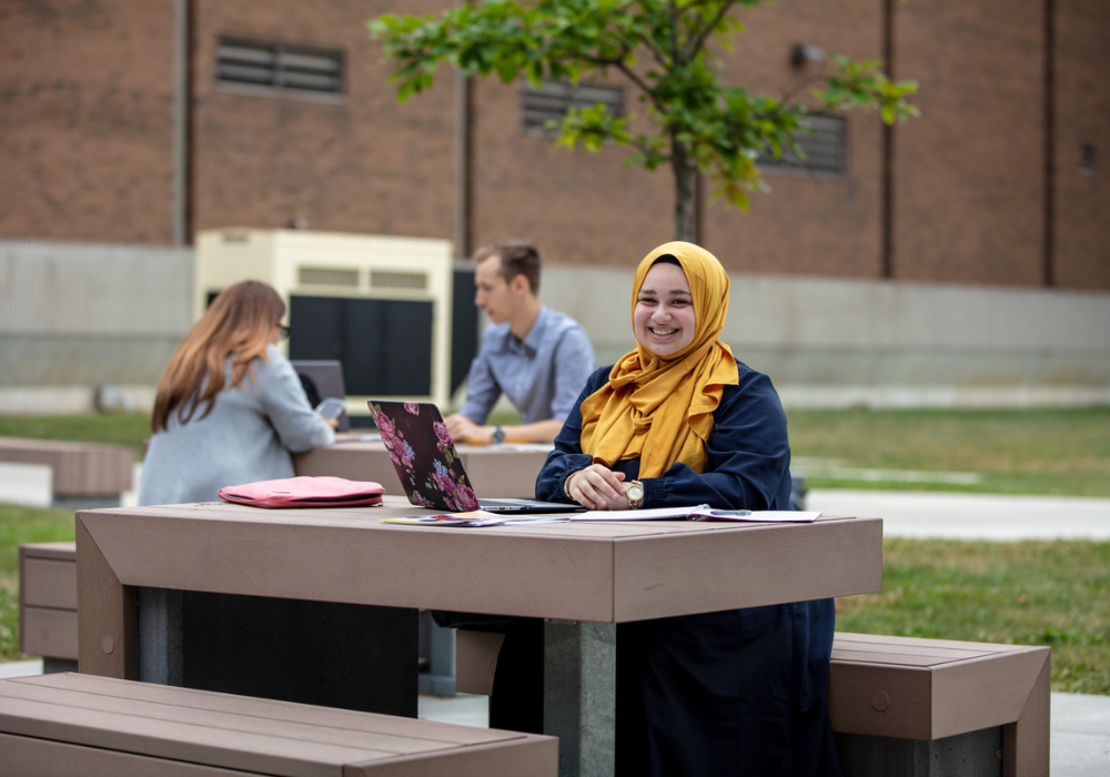 A student sat at a table on campus