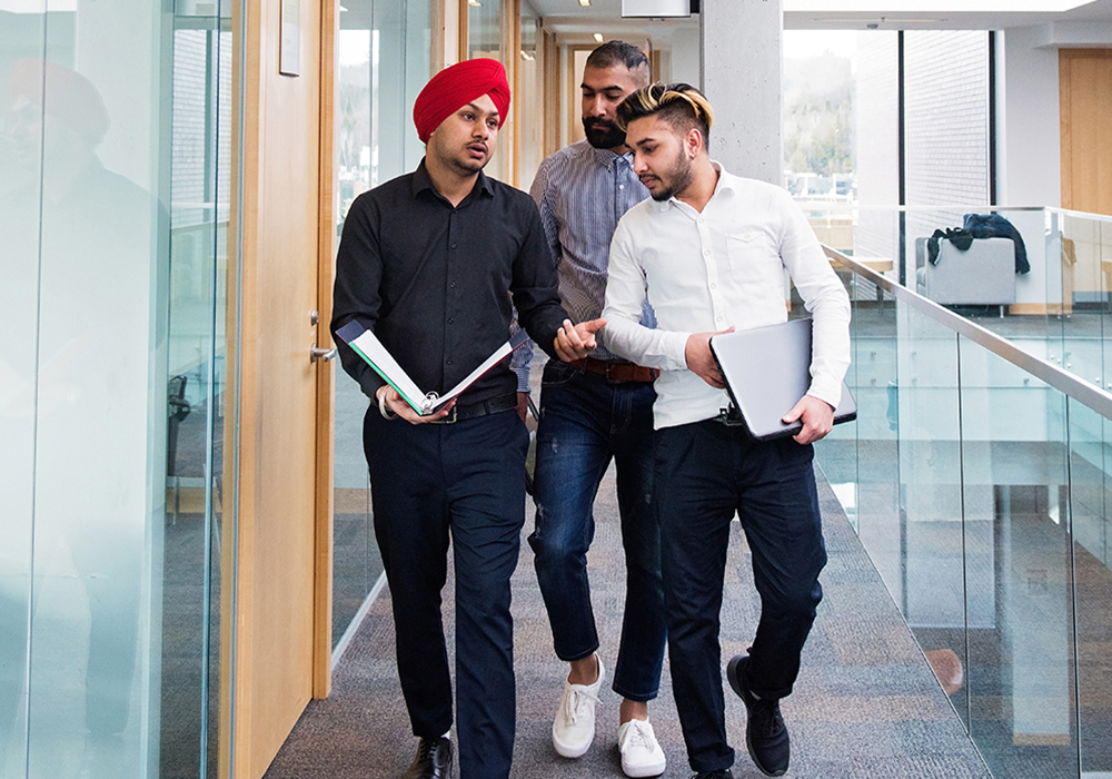 Group of male students walking through the library
