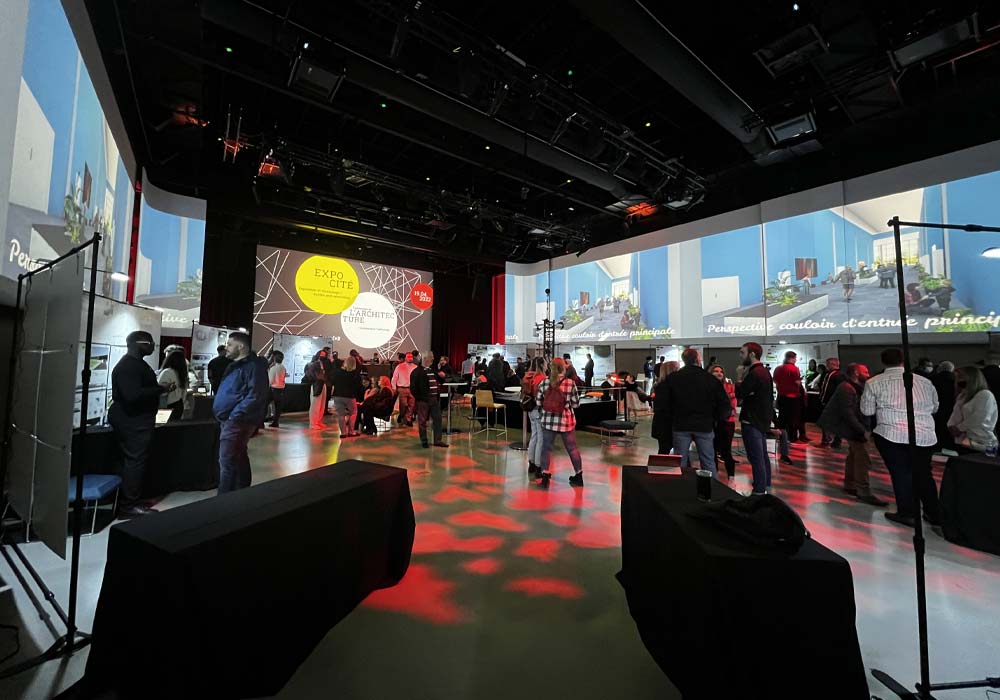 Des gens discutent en petits groupes lors d'une réception au pavillon Excentricité de La Cité.