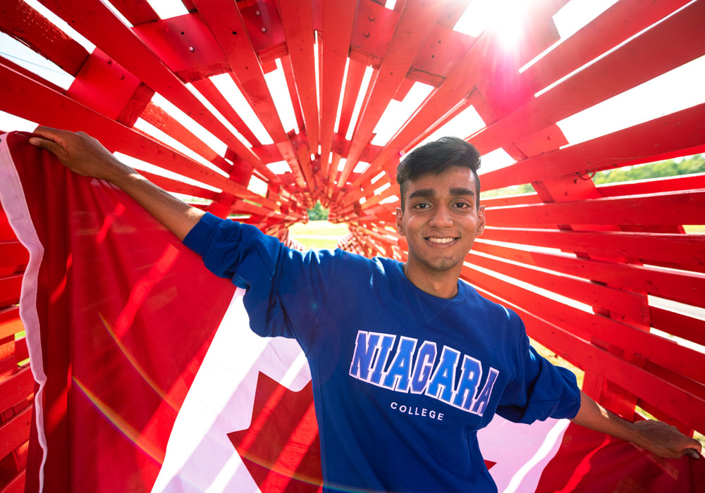 Niagara College student with Canadian flag