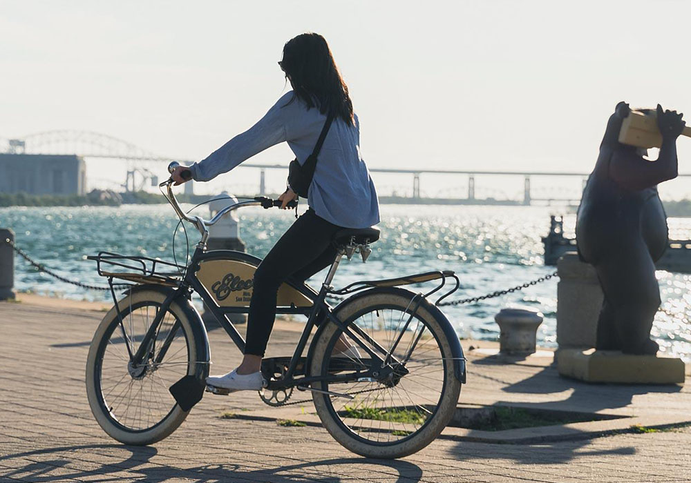 Student enjoying bike rental along Sault Ste. Marie's waterfront boardwalk