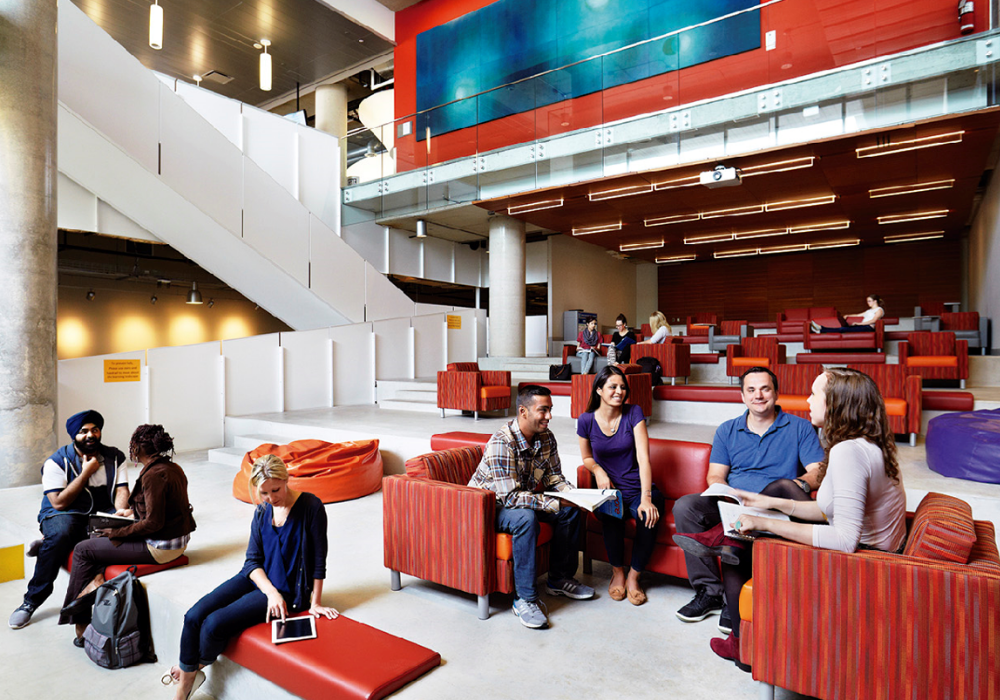 GBC students gathered in a communal space, sitting on couches and working.